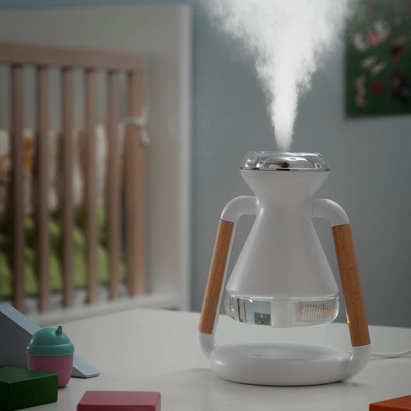 Humidificador en funcionamiento por la noche, con los indicadores LED encendidos, emitiendo una suave y constante pulverización.
